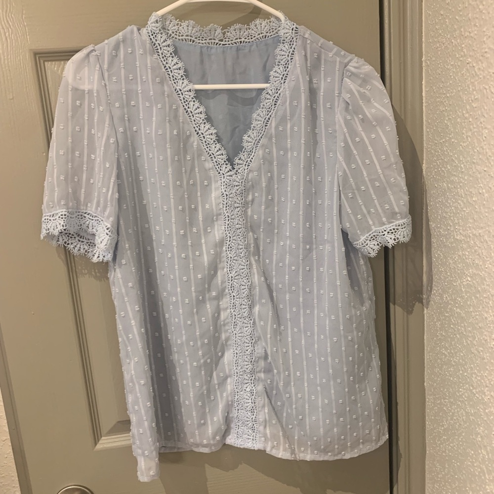Two work shirts. One blue. One pink.